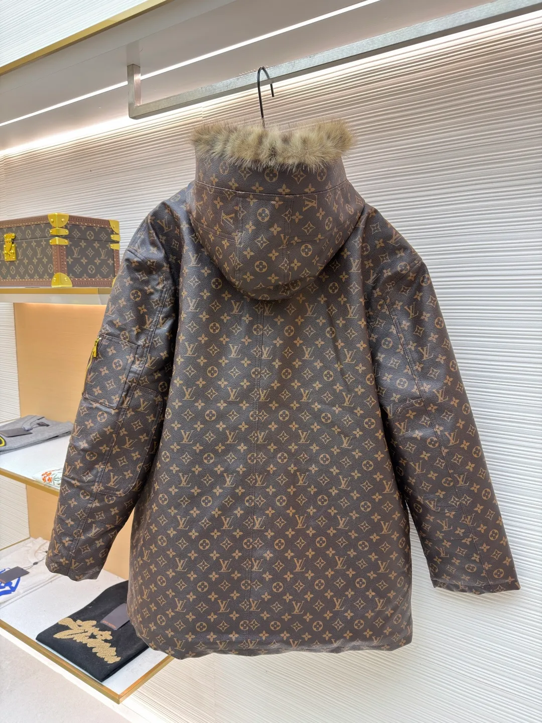 LOUIS VUITTON letter print hooded jacket ●Original version: Purchased and developed for 69999 ●Item number: 1681985-E40 ●Fabric: cotton fabric ●Technology: printing production ●Color: brown ●Version: fitted version ●Weight: about 1810 grams ●Size: 46-48-50-52 ●Description: This printed jacket is made of embossed leather fabric with a dark brown base and is fully printed with the classic Monogram pattern. The embossing process gives the logo a three-dimensional texture. The edge of the hood is spliced ​​with a natural fur collar, and the brim is equipped with an adjustable drawstring (metal rope buckle) to enhance warmth and style. The placket is double-closed with a two-way metal zipper and brass snap buttons. The zipper puller and snap button are both engraved with the brand logo, which is thick and durable. The body is designed with multiple pockets, and the pockets are edged with the same material + metal snap buttons for reinforcement. The left sleeve is equipped with a hidden adjustment tab. The interior is filled with high-fill down cotton, and the stitching adopts diamond-shaped quilting technology to prevent the filling from shifting. The seams are edged with leather of the same color, and the overall wiring is precise, taking into account warmth retention and luxurious texture. The overall wiring is straight and delicate, the fabric is comfortable and soft, and the color is consistent without color difference. It can be matched with the same style to create a fashionable look and control various occasions. Customized accessories, complete with three standards, same style for men and women!